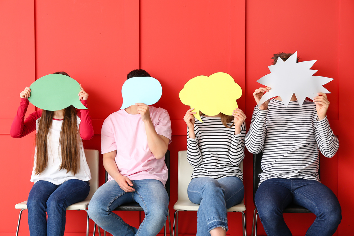 Group of Young People with Blank Speech Bubbles on Color Background